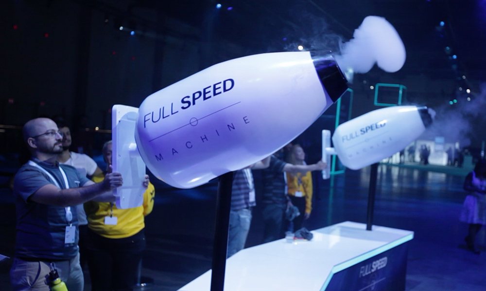 Attendees aiming the Full Speed Machine fog cannons, one firing a smoke ring
