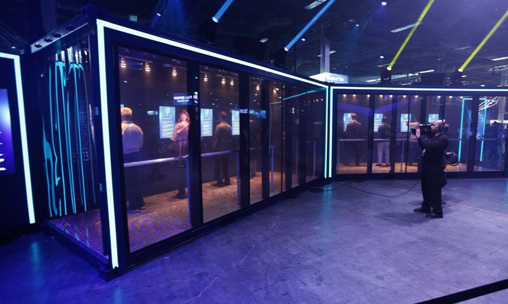 Exterior of the illuminated Laser Maze Challenge structure on the show floor