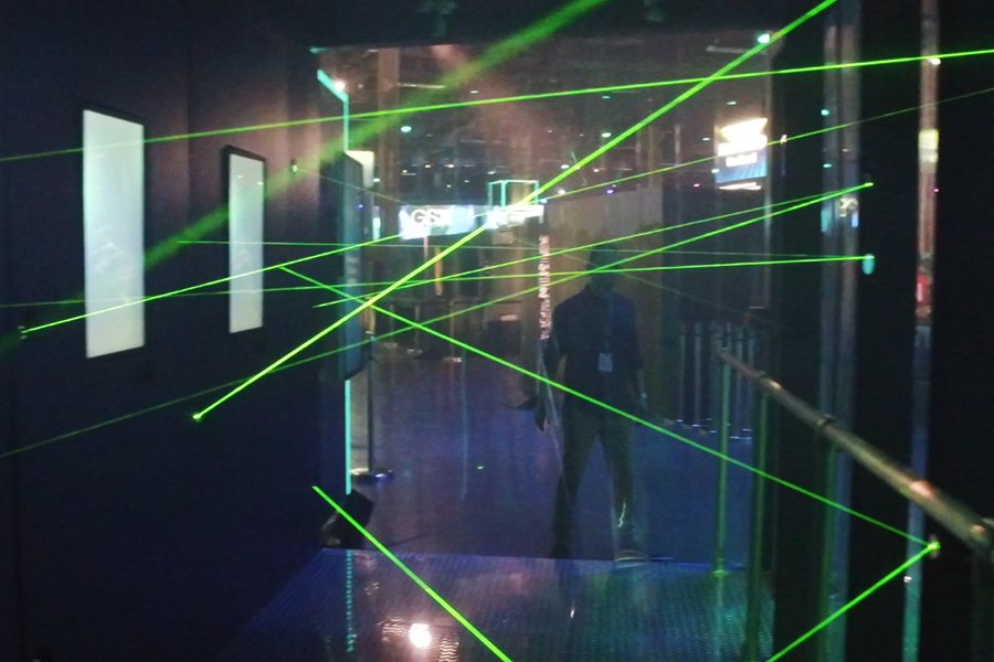Attendee navigating a web of green lasers inside the Laser Maze Challenge