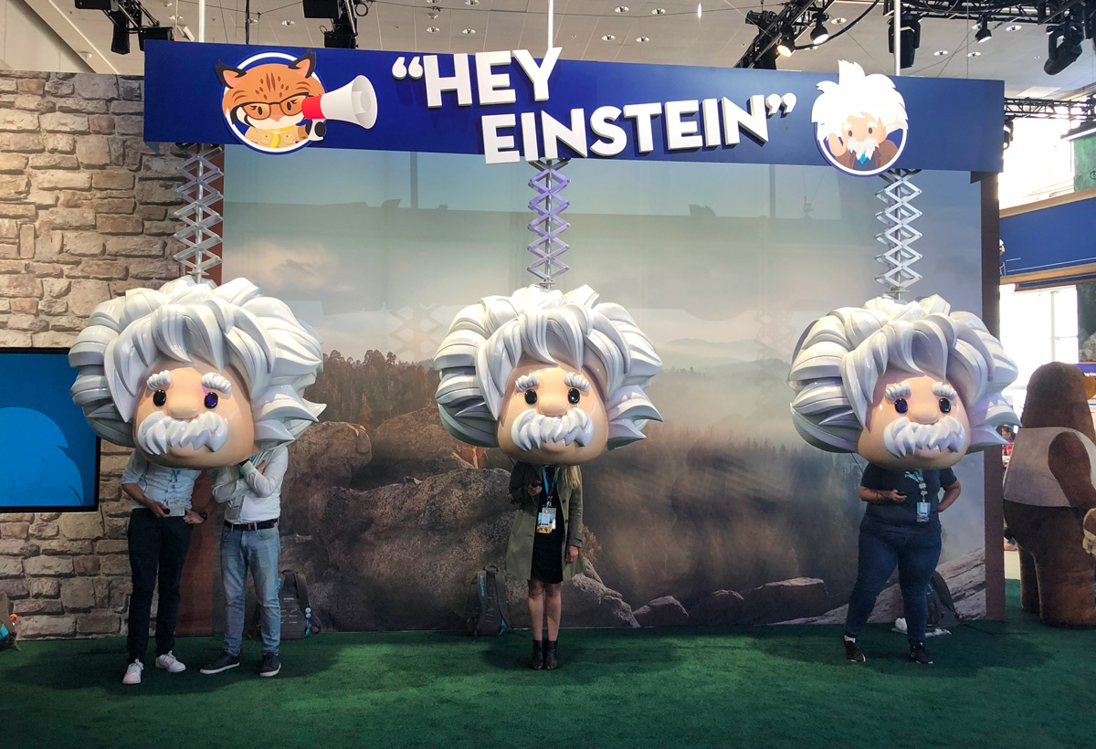 Guests posing with the Hey Einstein bobbleheads beneath the activation's marquee sign