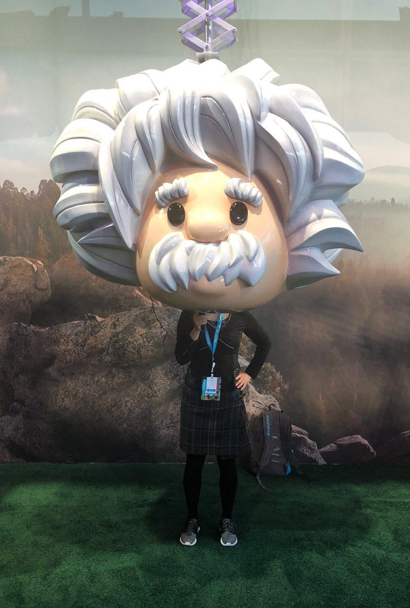 A guest standing beneath a giant Einstein bobblehead head prop