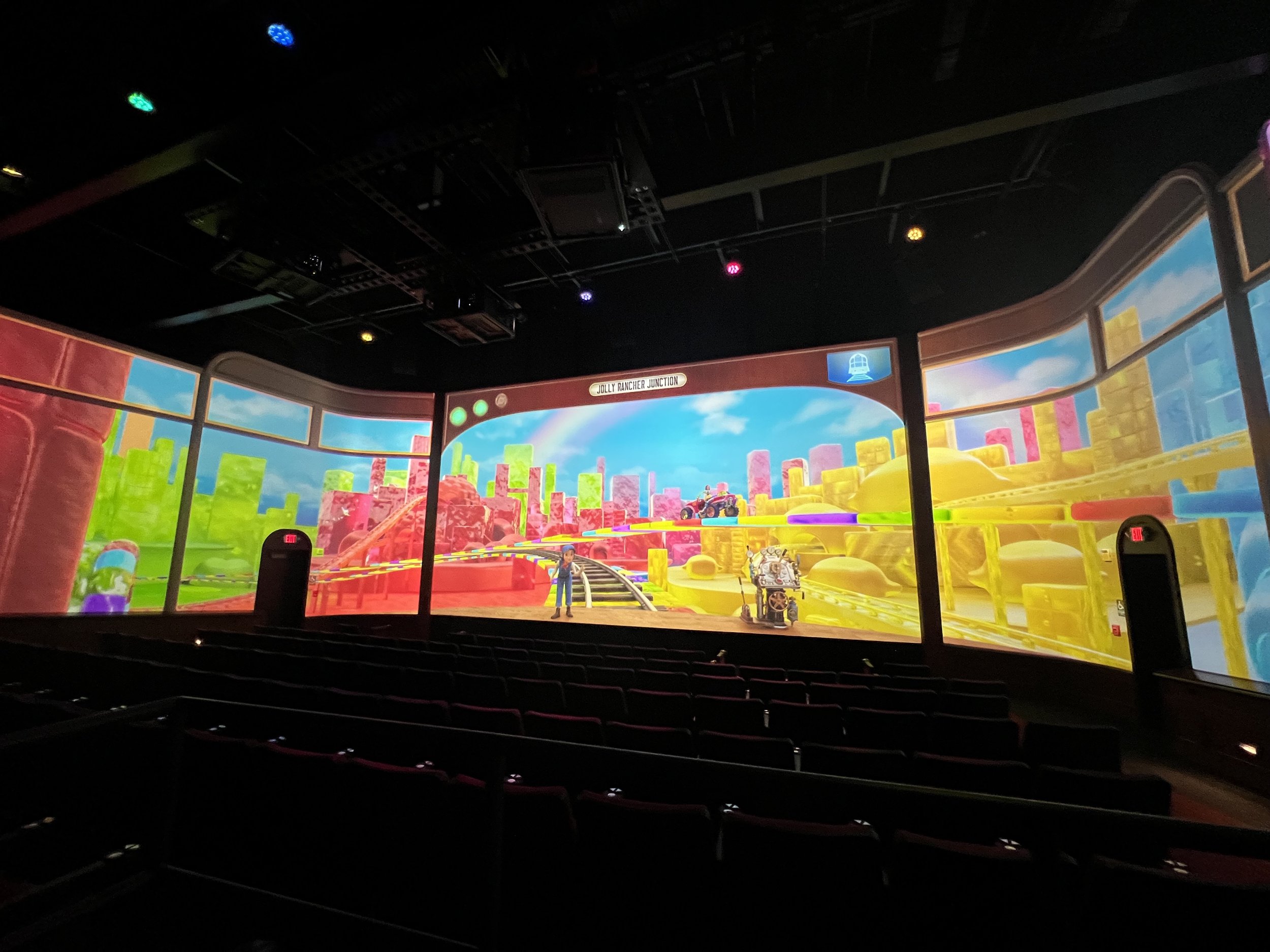 Wide 270-degree theater screen showing a candy-themed cityscape