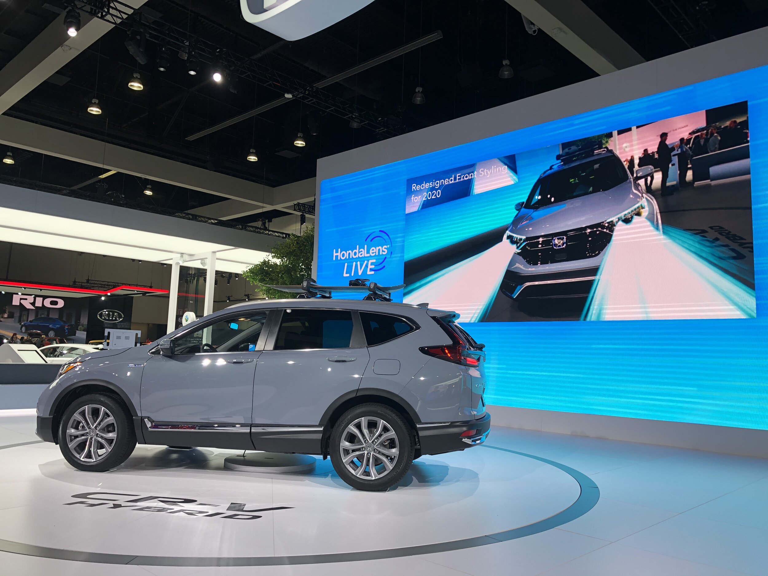 A presenter standing beside the Honda CR-V Hybrid with AR content tracked live onto the vehicle
