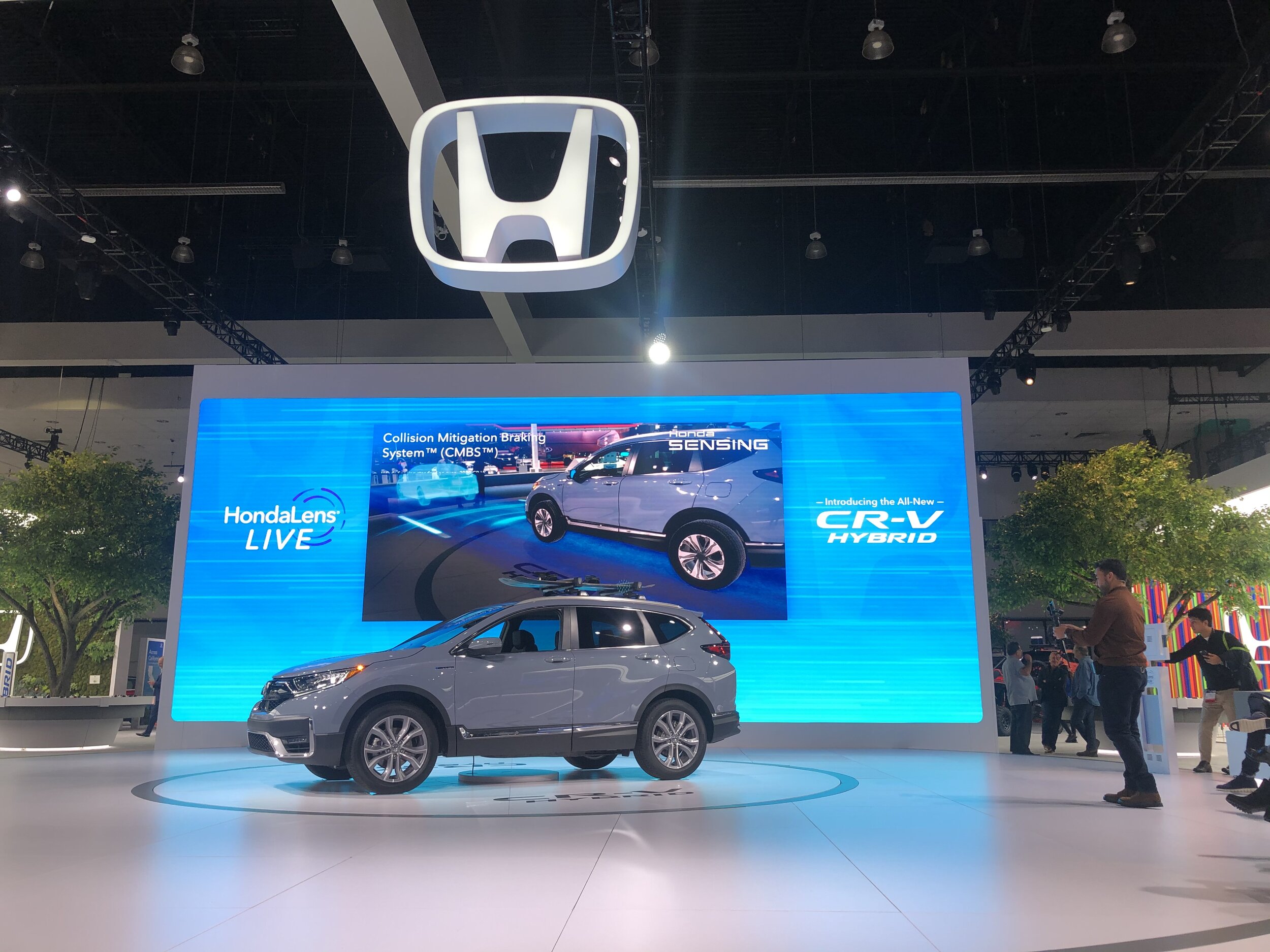 Presenter gesturing beside the vehicle as AR content streams to the LED wall
