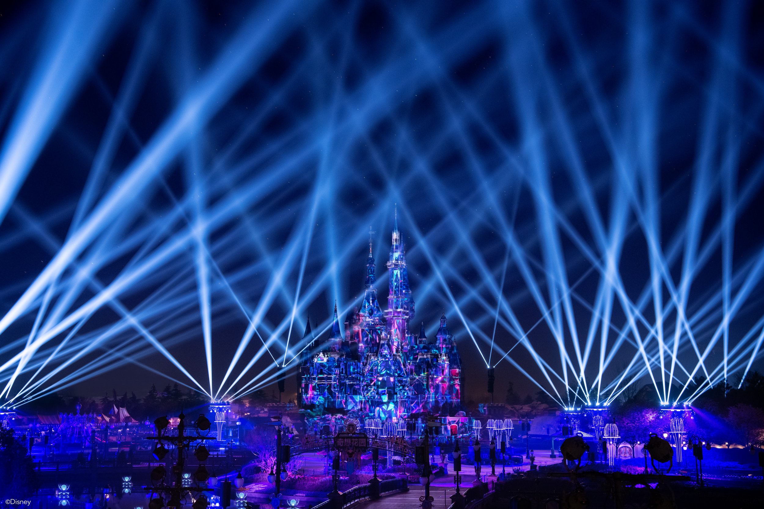 Blue laser beams crossing in front of the castle during the show