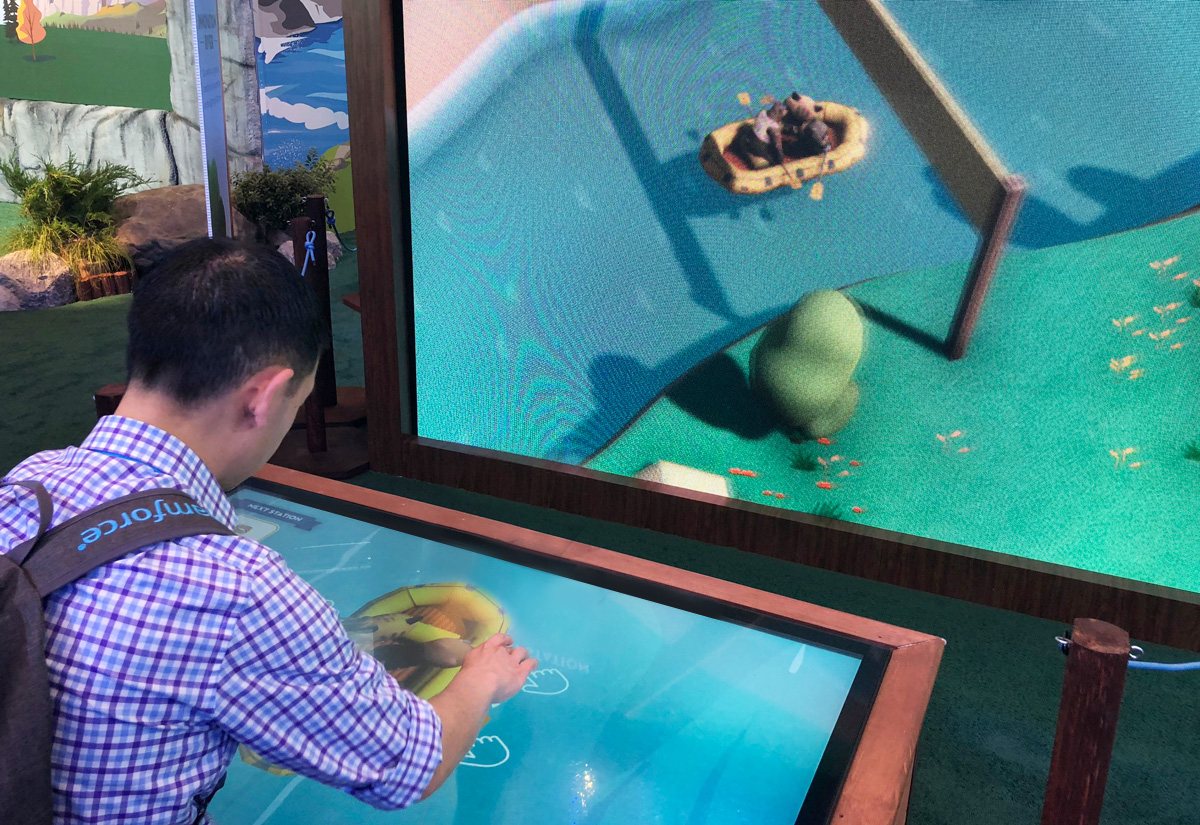 Guests interacting with the Lightning Innovation River touchscreen table