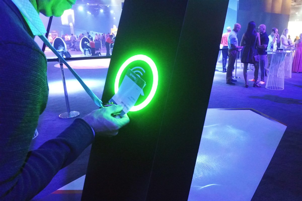 Close-up of an attendee tapping their badge to activate a wayfinding portal
