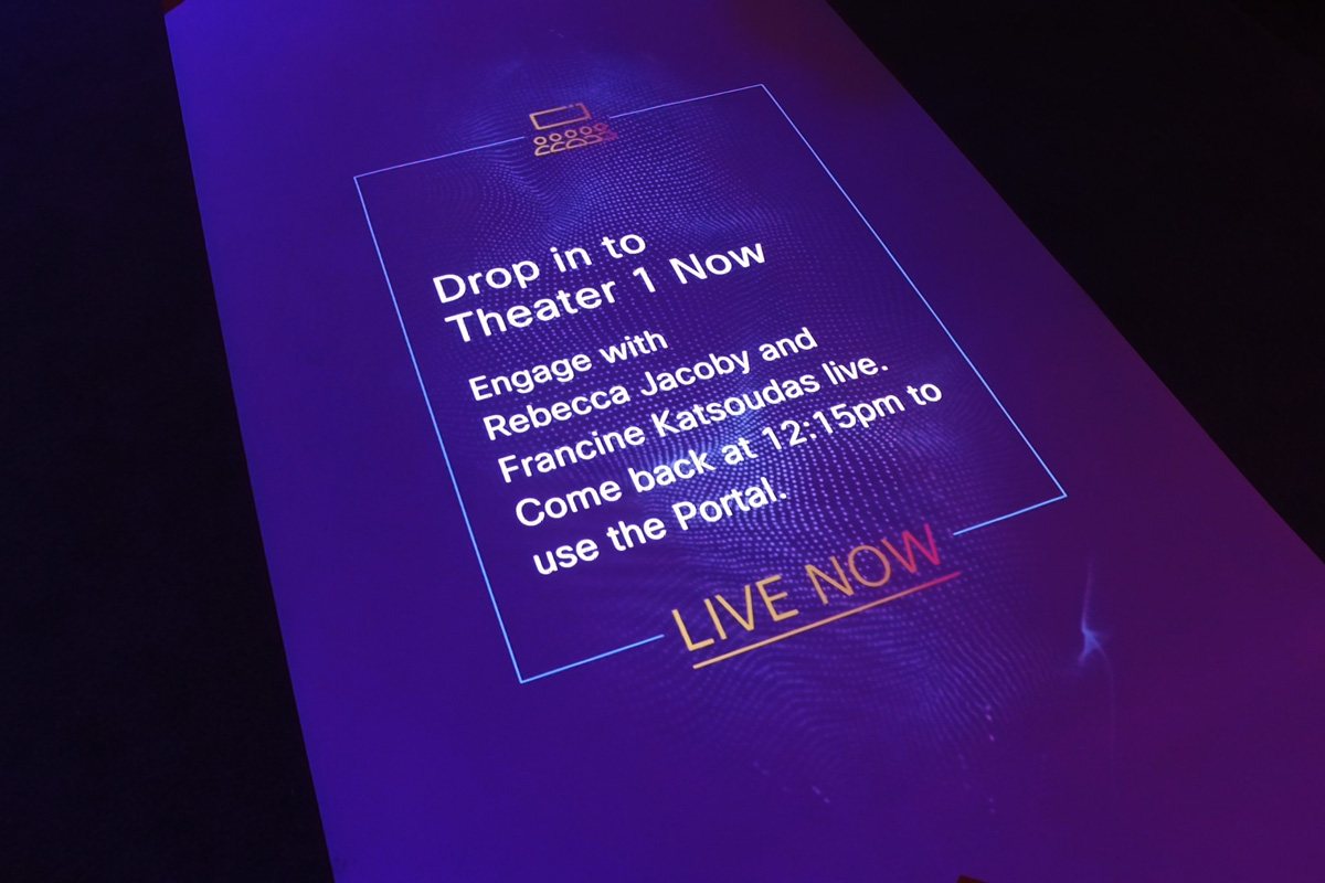 Close-up of the projected floor screen inviting attendees to drop in to Theater 1
