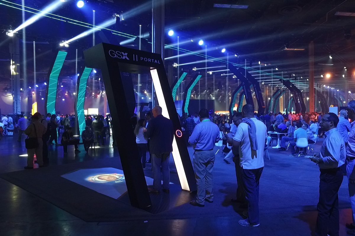 Wide shot of the GSX Portal arches glowing among the crowded show floor