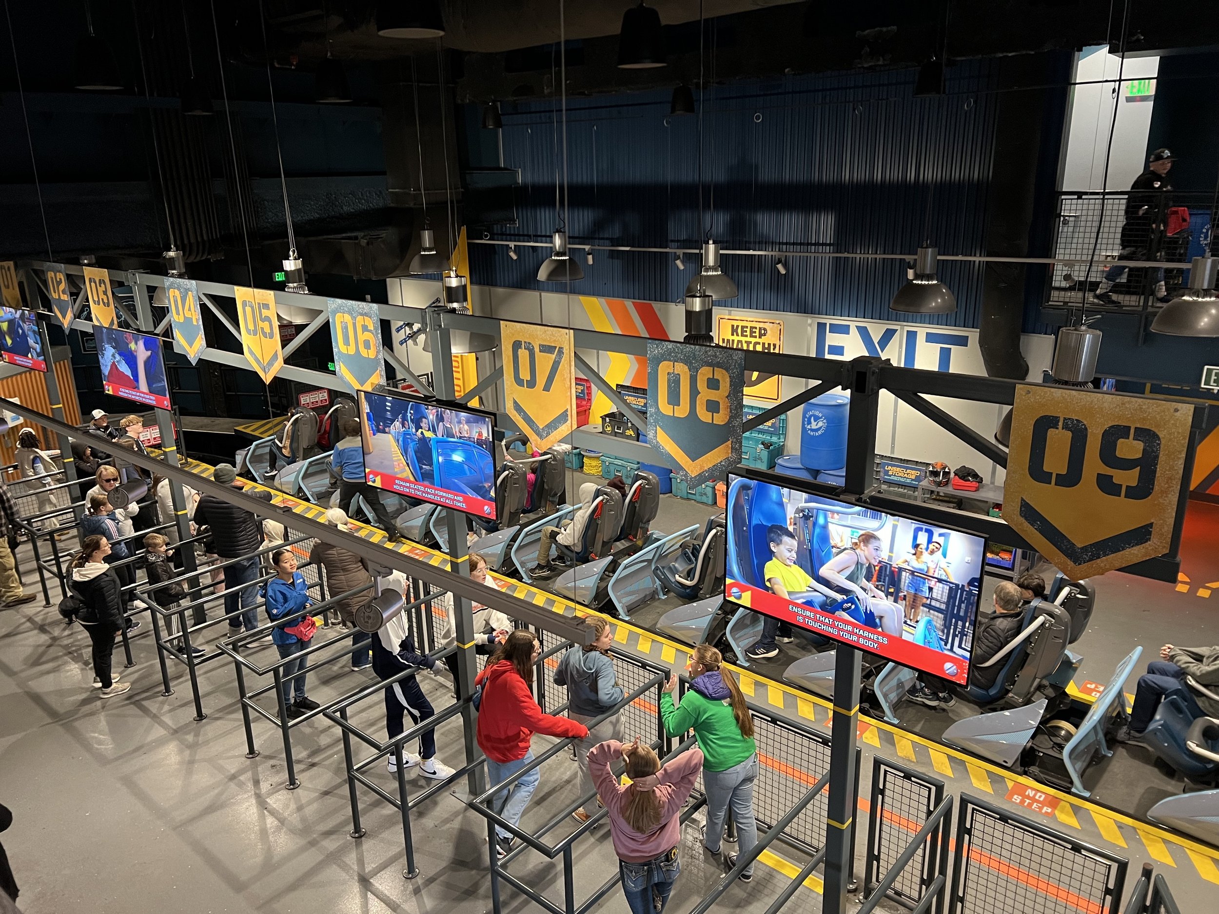 Guests queuing past numbered ice cave station screens