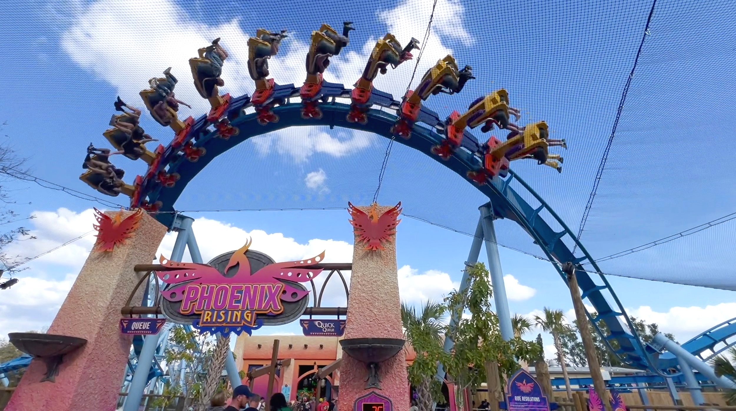 Coaster train inverted over the Phoenix Rising queue archway