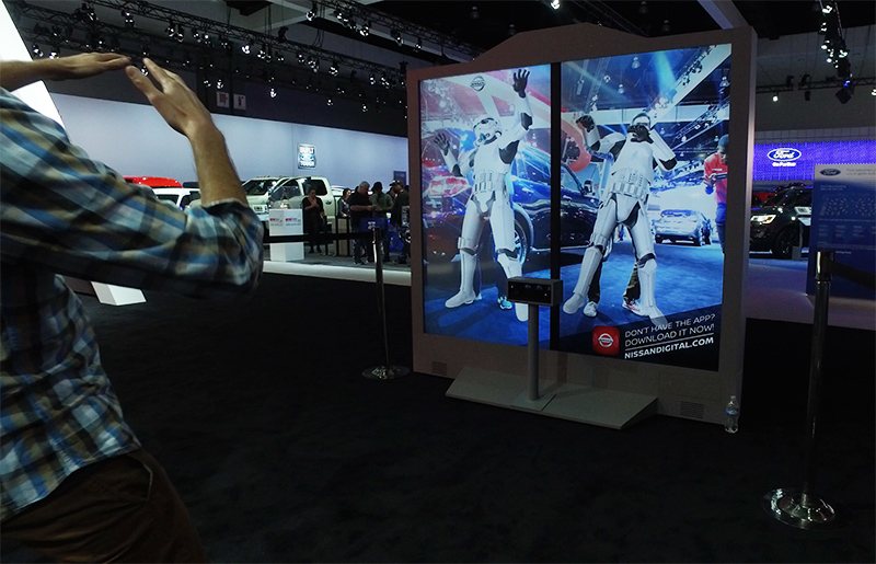 Guest raising their arms in front of the motion-tracking Stormtrooper mirror display