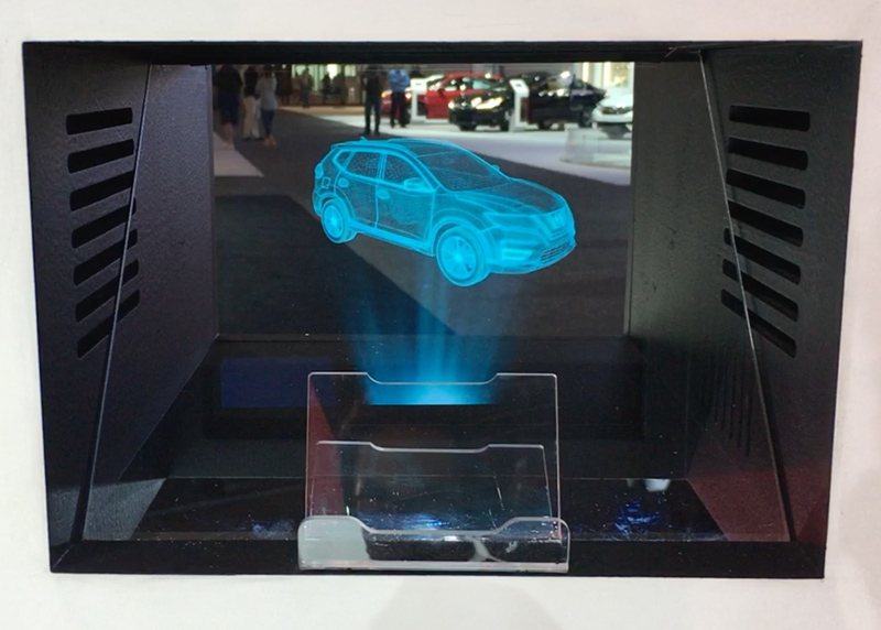 Holographic display box projecting a wireframe Nissan Rogue on the show floor